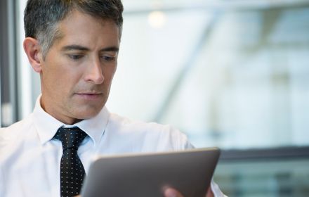 Mann schaut auf Tablet