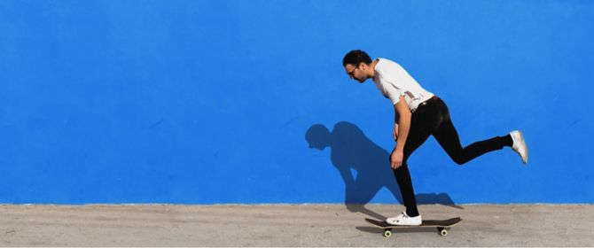 Guy on skateboard in front of blue wall