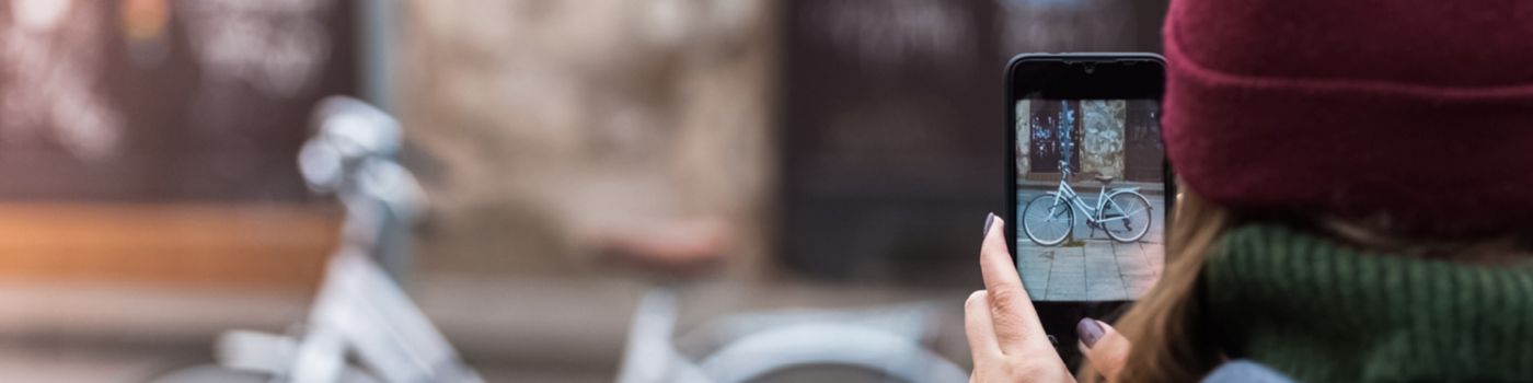 Woman takes picture of bicycle with mobile phone