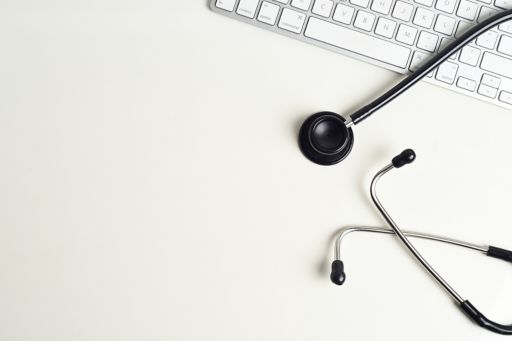 Keyboard and a stethoscope on white background
