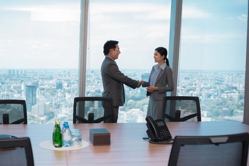 Woman and man shaking hand in a meeting room