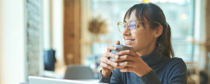 Femme devant un ordinateur portable avec un café