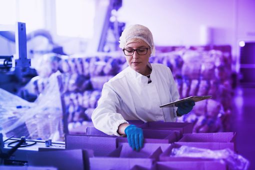 woman working in factory checking boxes