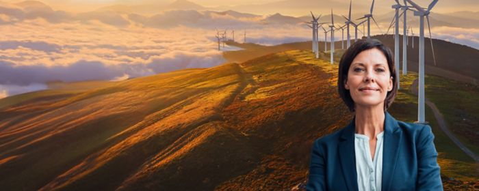 Une femme devant des montagnes et des éoliennes