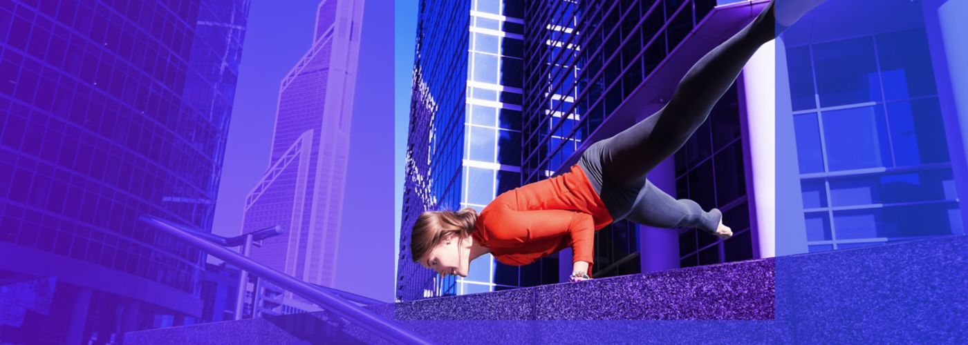 woman keeping balance on both her hands in front of buildings