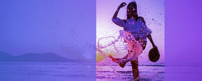 woman kicking water whilst holding hat in hand