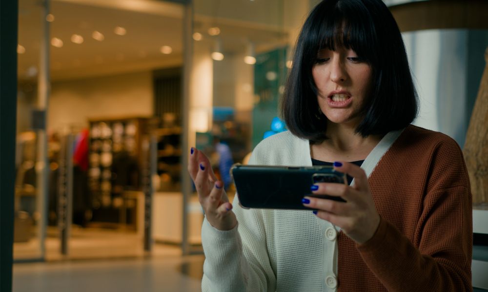 Woman looking frustrated at cell phone