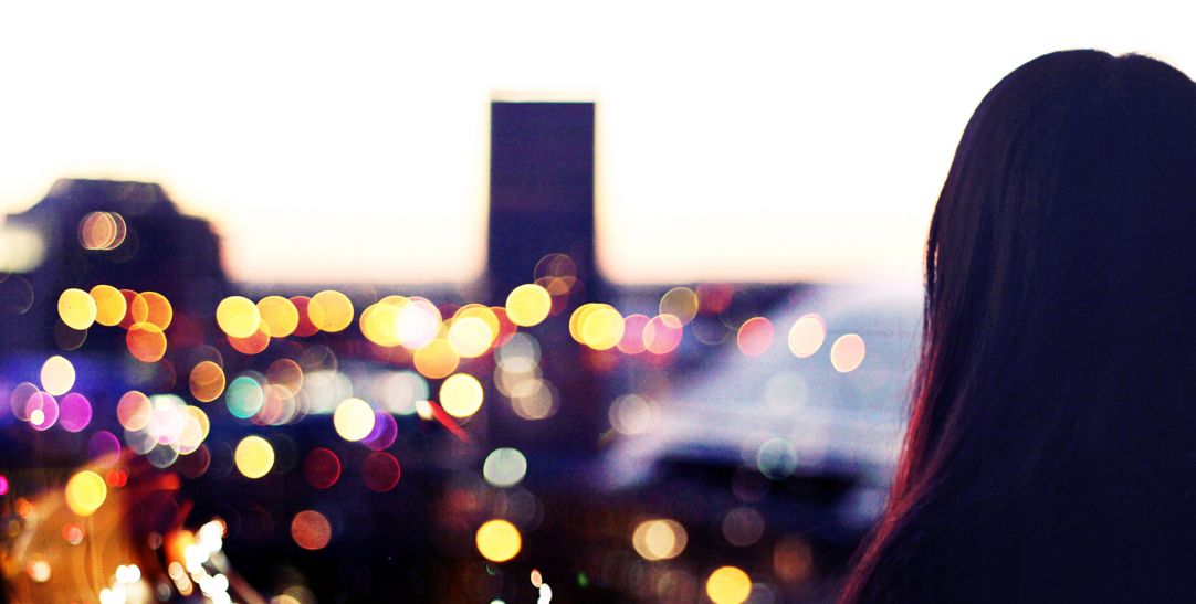 Woman looking at the city from the balcony