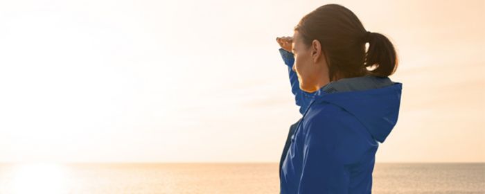 woman on beach looking towards sun