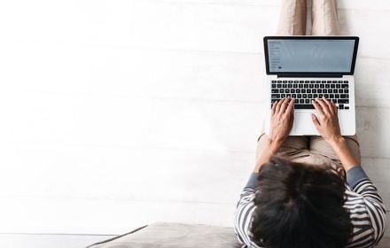 Woman sitting on sofa and woring on laptop