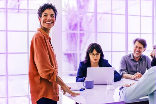 Woman smiling in meeting with colleagues