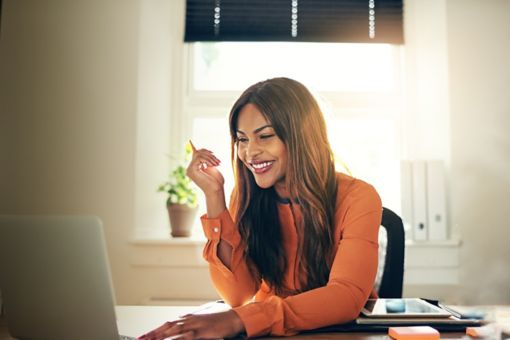 Woman smiling while looking at laptop