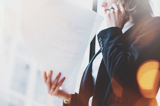 Woman talking on the phone and holding paper