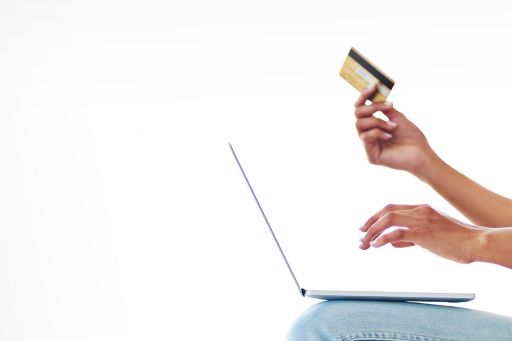 a woman using her credit card to make an online payment at home