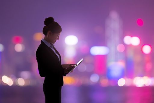 Woman using tablet with skyline background