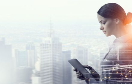 Woman with tablet superimposed over city skyline
