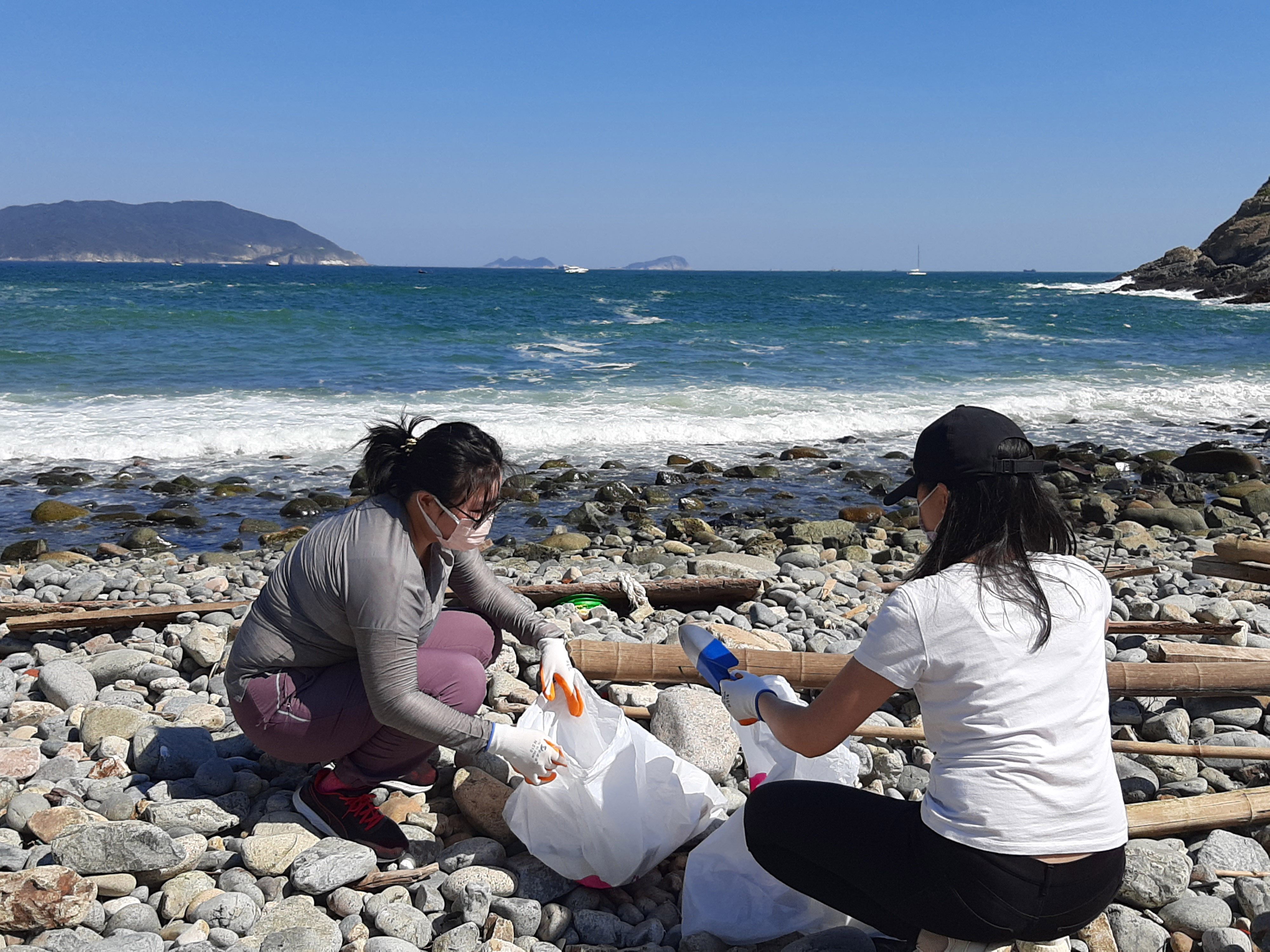 Women cleaning beach shore