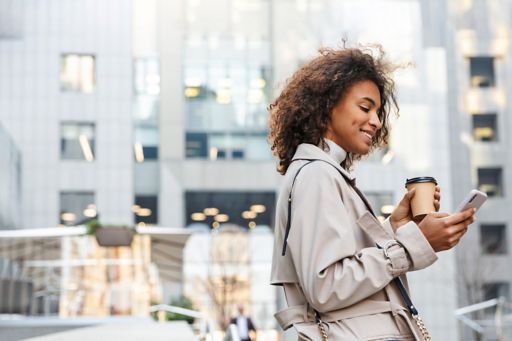 Woman drinking coffee and checking phone