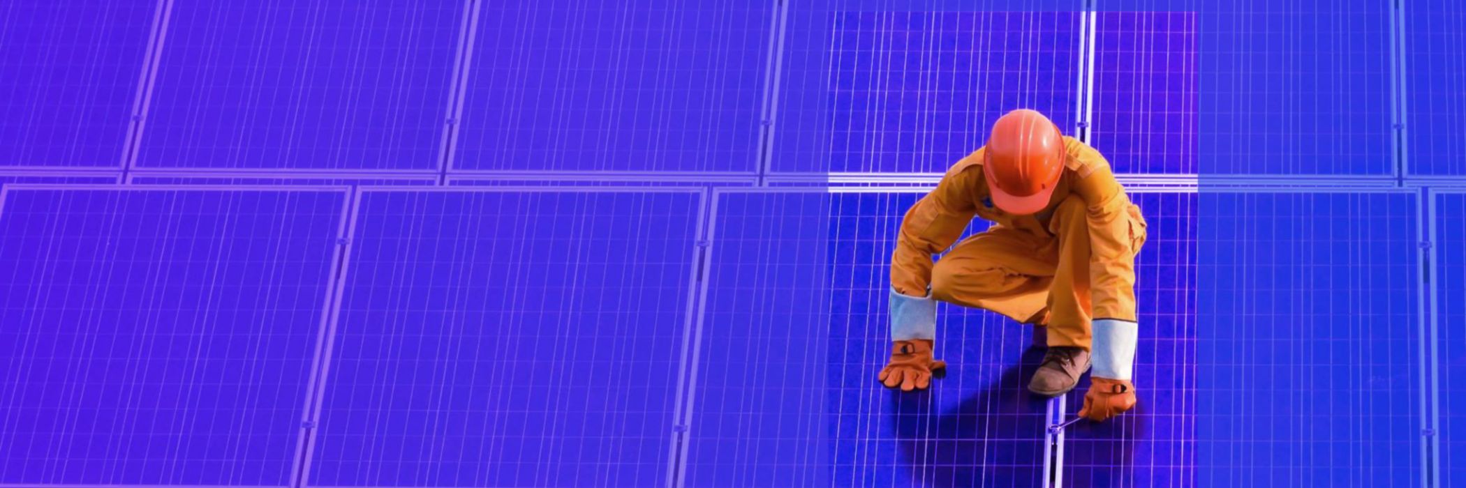 worker standing on solar panel fixing 