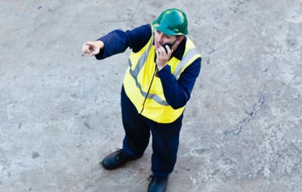 Worker using walkie-talkie on dock