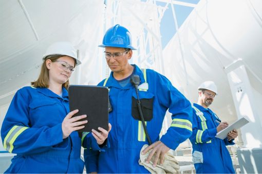 Workers on construction site holding tablet
