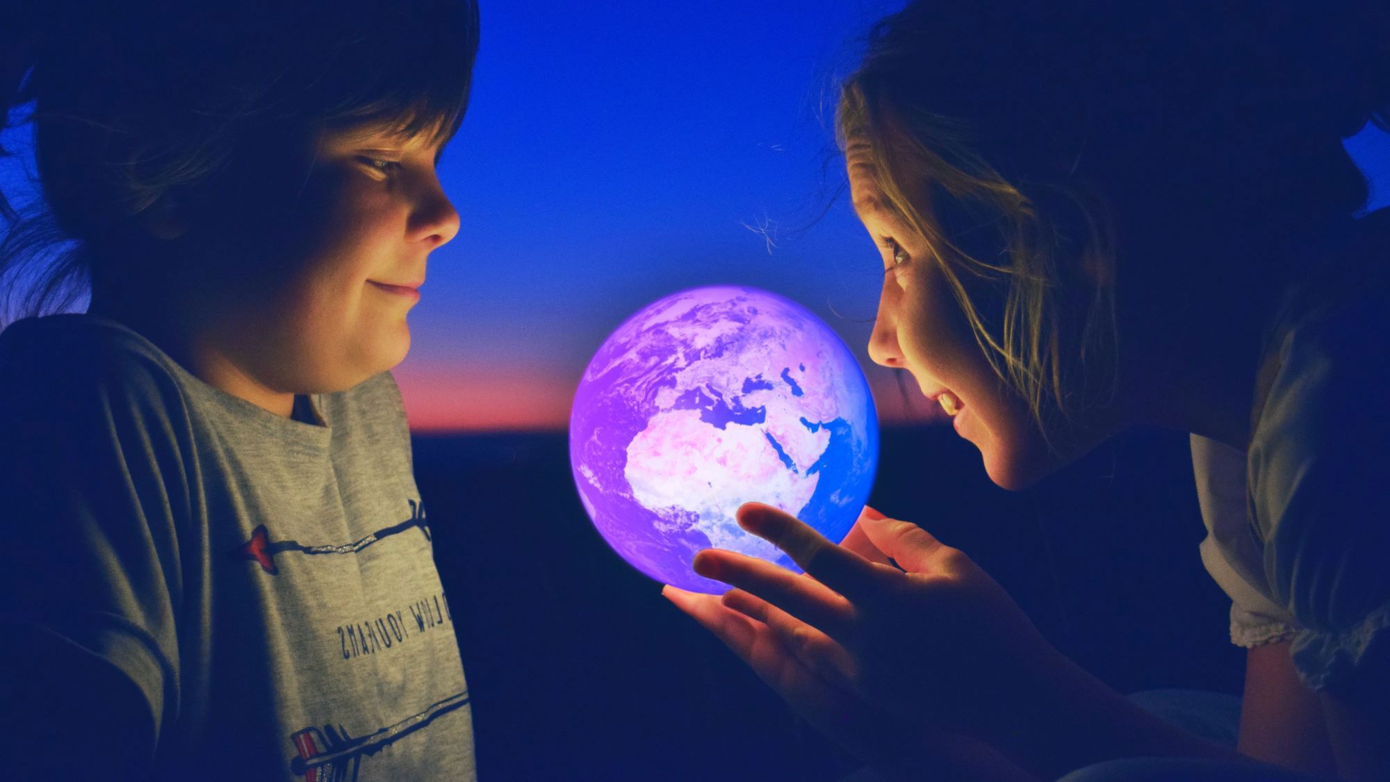 kids looking at globe