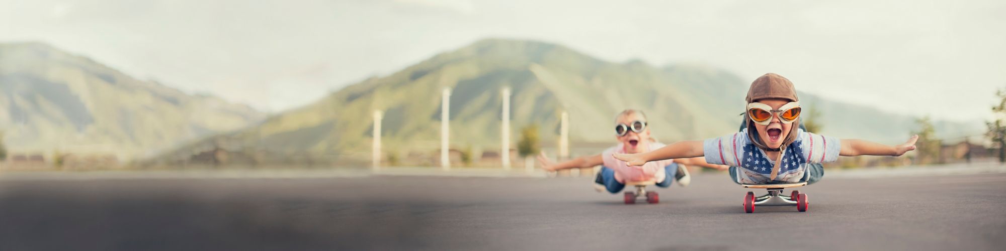 Young children on skateboards imagine they are flying