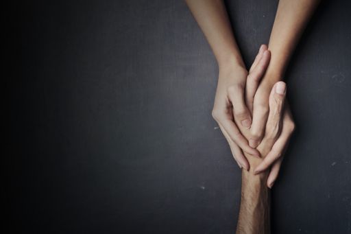 Young person hands holding old age person hand