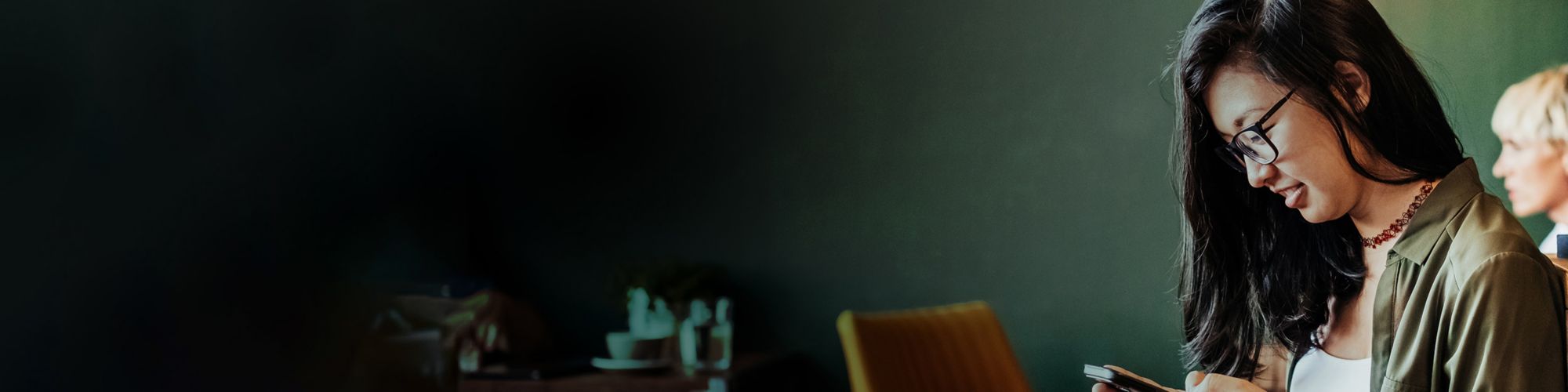 Young woman sitting in cafe using smartphone