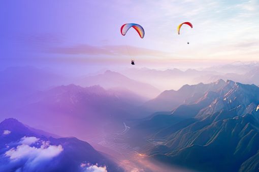 Two paragliders flying above mountains