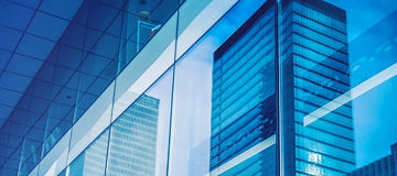 Geschäftsfrau, die in einem modernen Büro Notizen auf eine Glaswand schreibt.