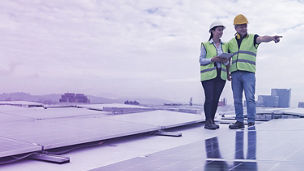 Two persons walking over solar panels