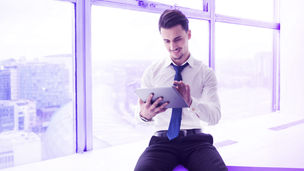 hombre usando una tablet sentado cerca de la ventana