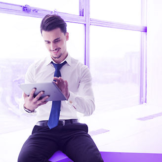 hombre usando una tablet sentado cerca de la ventana