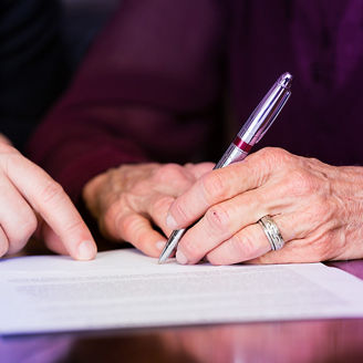 Hände unterschreiben ein Dokument