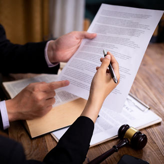 Two people are holding papers and pointing with a pen
