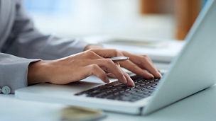 Hands writing on a laptop