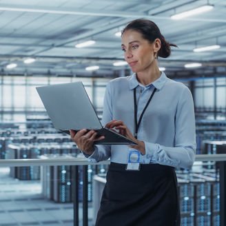 Woman working on laptop in data center