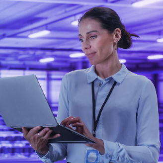 Woman working on laptop in data center