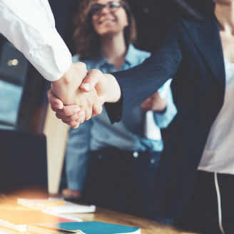 Young business people shaking hands in the office. Finishing successful meeting. Three persons
