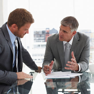 Dois homens conversando em uma mesa de escritório