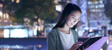 A woman using a tablet in hand in an outdoor environment