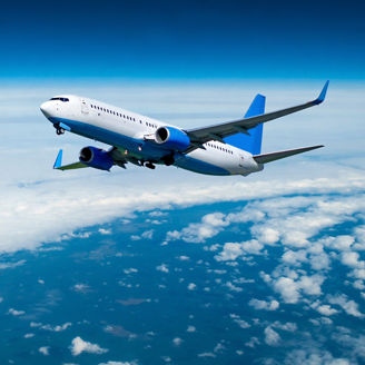 Commercial airplane flying over the clouds, air travel background with white airplane in the flight among high clouds in the atmosphere