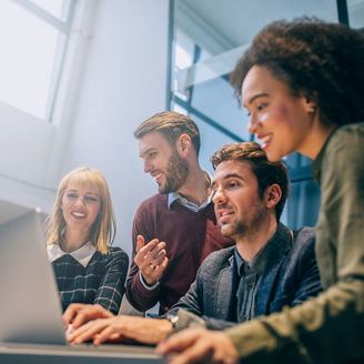 Shot of a group of coworkers discussing something while looking at a laptop computer