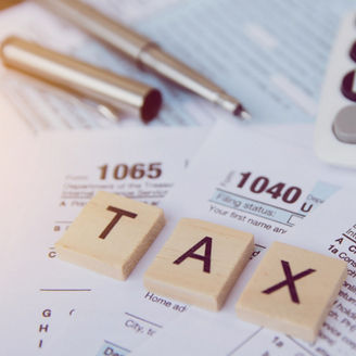 Tax season with wooden alphabet blocks, calculator, pen on 1040 tax form backgrounda