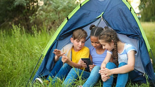 Crianças em uma cabana olhando um tablet