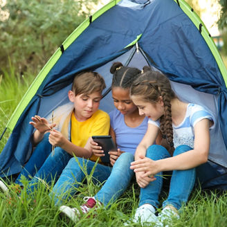 Crianças em uma cabana olhando um tablet