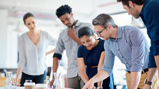 Mature man describing a plan of action to his diverse creative team.