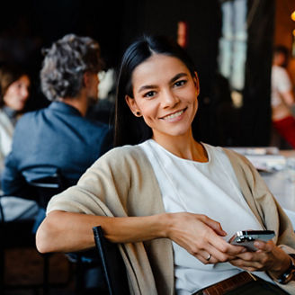 Uma mulher segurando um celular em sua mão