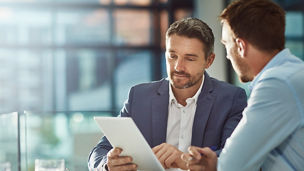 Teamwork meeting, tablet and business people in office workplace. Collaboration, technology and workers, men or employees with touchscreen planning sales, research or financial strategy in company.